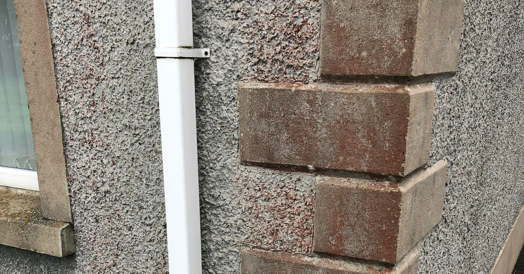 Why can white patches appear on softwashed pebble-dash render?